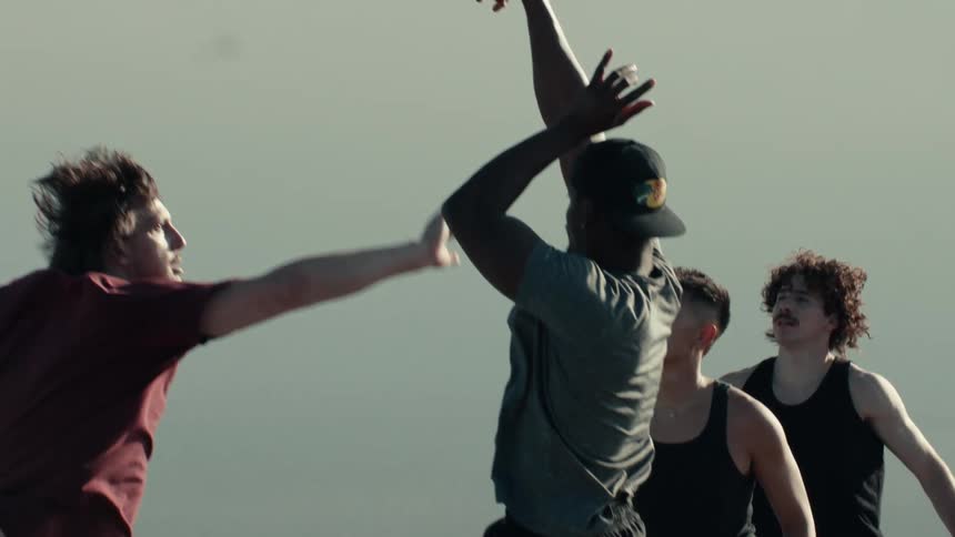 A basketball player jumps to take a shot as his opponent leaps to block him during a game with friends in slow motion