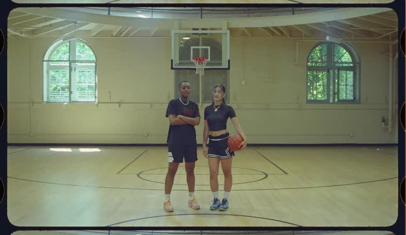 Portrait of two diverse female basketball players standing confidently on a gymnasium court