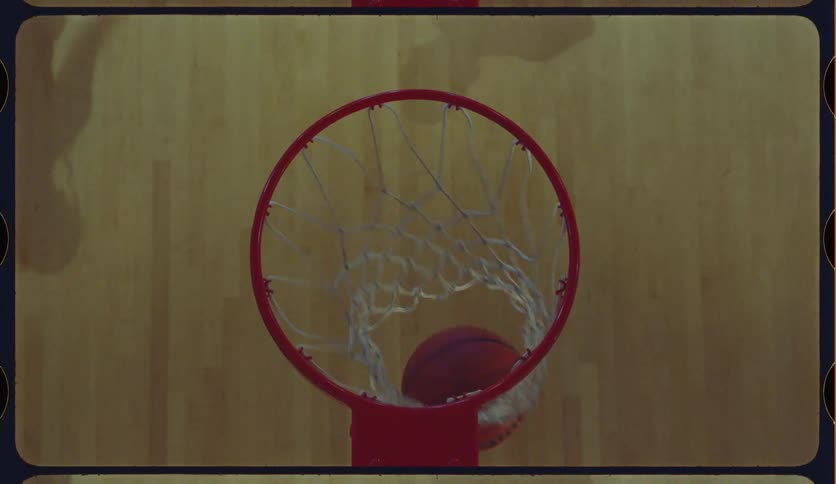 Top-down vintage-style shot of a person making several baskets while practicing on an indoor basketball court