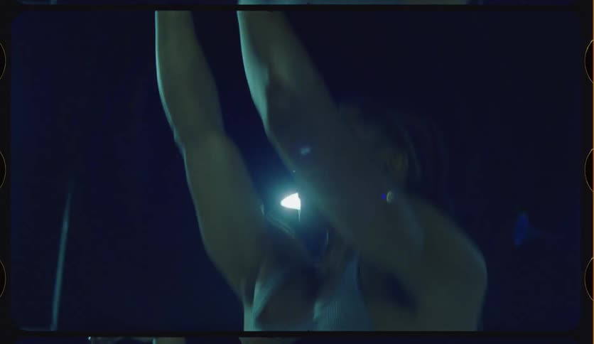Vintage-style slow-motion close-up of a basketball player practicing his shot on a dark court at night