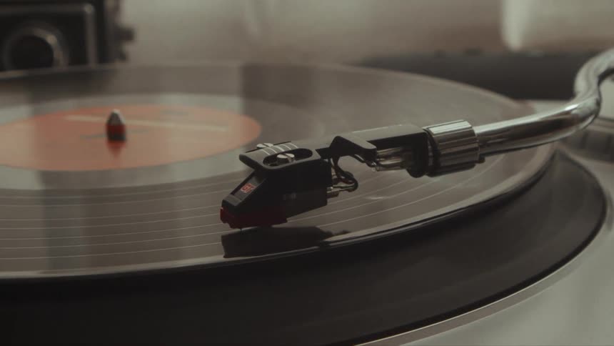 Close up of a spinning vintage vinyl record player with a stylus on the record