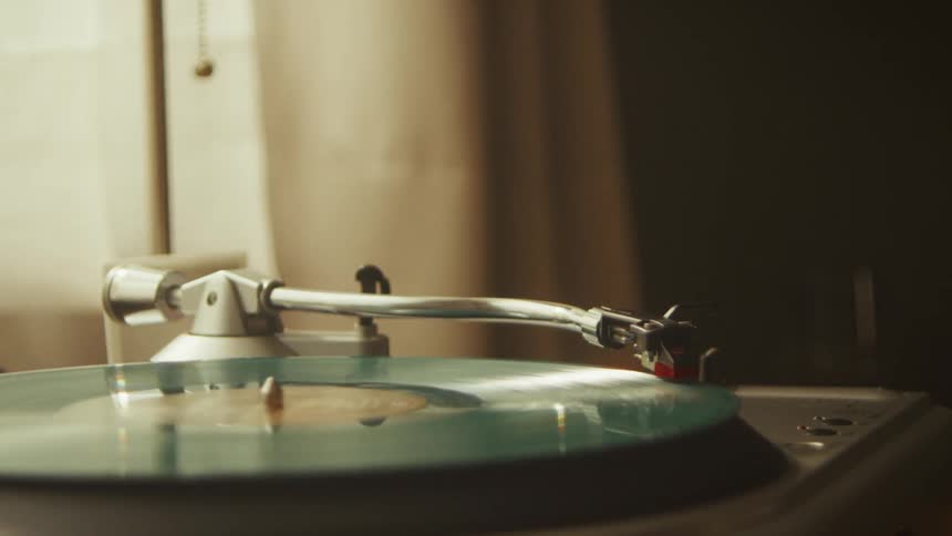 Close-up of a stylus tracing the grooves of a colorful vinyl record on a vintage turntable