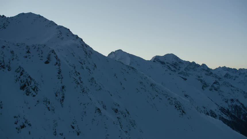 The pointy mountain top is covered with snow