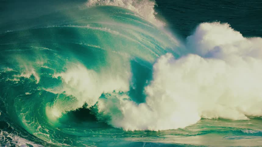 A massive ocean wave curls and breaks in dramatic super slow motion