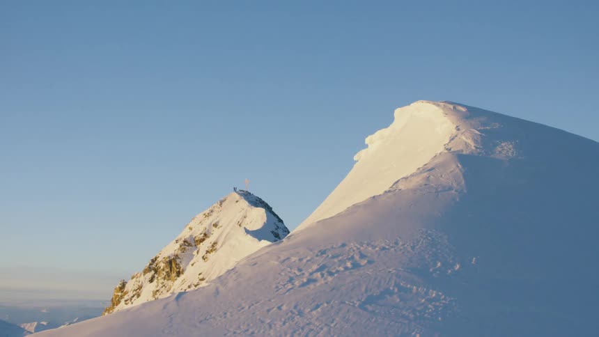 The mountain top if covered with snow