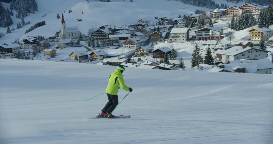 A person in a yellow jacket is skiing