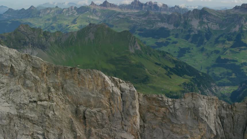 A rocky mountain ridge is shown with a valley beyond