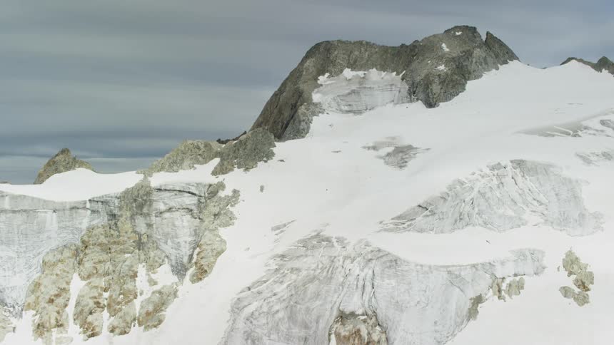Aerial view of snow-covered mountains on a cloudy day