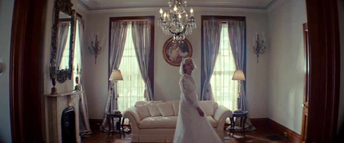 Slow-motion shot of a senior woman in a wedding dress reminiscing and dancing alone in an elegant living room