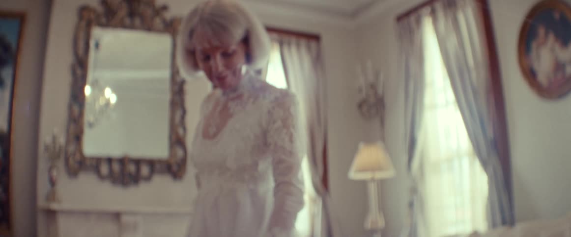A beautiful senior bride with grey hair lovingly adjusts her elegant lace wedding dress in slow motion