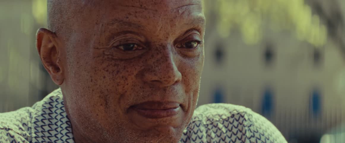 A close-up portrait of a senior man with a kind and gentle expression listening thoughtfully in a warm, sunlit setting