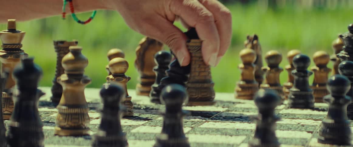A player makes a strategic move, capturing a knight with a rook during a game of chess in a park