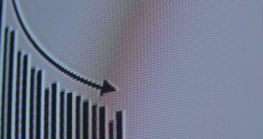 Macro shot of a financial chart on a computer screen indicating a downward trend with a black arrow