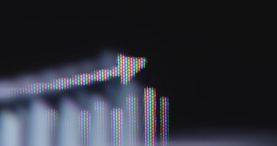 An extreme close-up of a screen displays a fluctuating business graph with a prominent upward arrow, symbolizing financial growth and positive trends