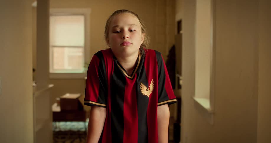 A young girl in a soccer jersey takes a deep breath to mentally prepare before her game