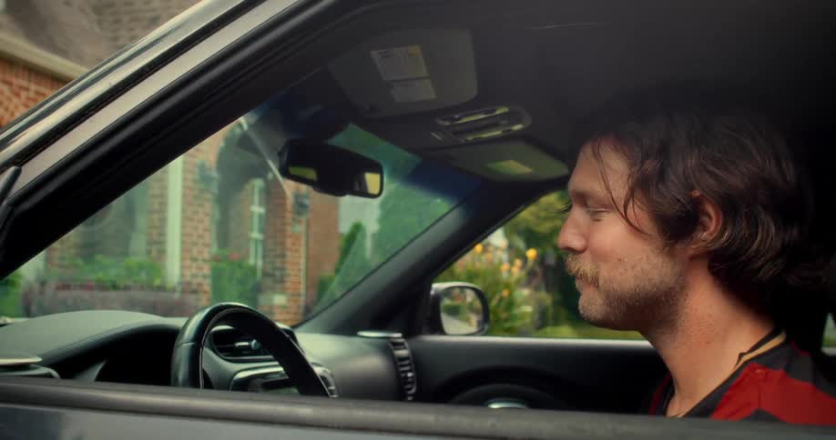 A smiling man with a mustache drops a woman off at her house, they wave goodbye, and he drives away
