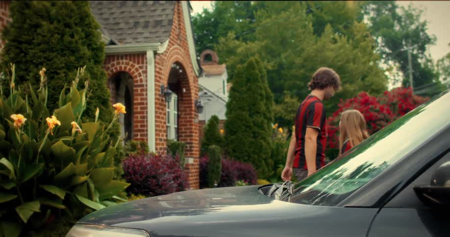 A father shares a heartfelt and somber goodbye hug with his young daughter in their suburban driveway