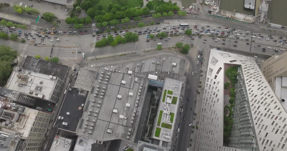 Top-down aerial view of Manhattan streets slowly flies forward and tilts up to reveal the Hudson River and New Jersey