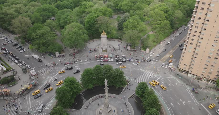 A high-angle aerial view of traffic at Columbus Circle slowly tilts up to reveal the vast greenery of Central Park and the Manhattan skyline
