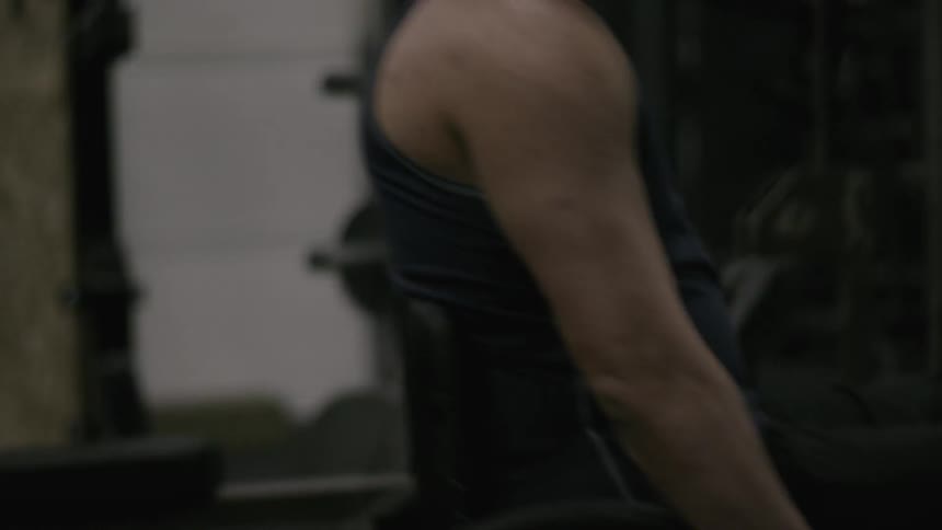 A man in a wheelchair rolls through a weight room