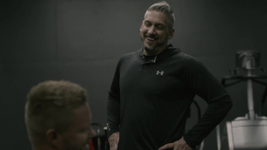 Men chat and laugh in a weight room