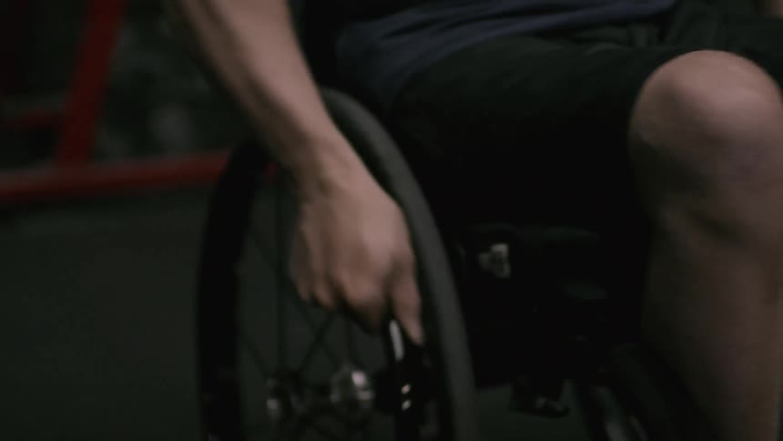 Man wheels himself around in a wheelchair