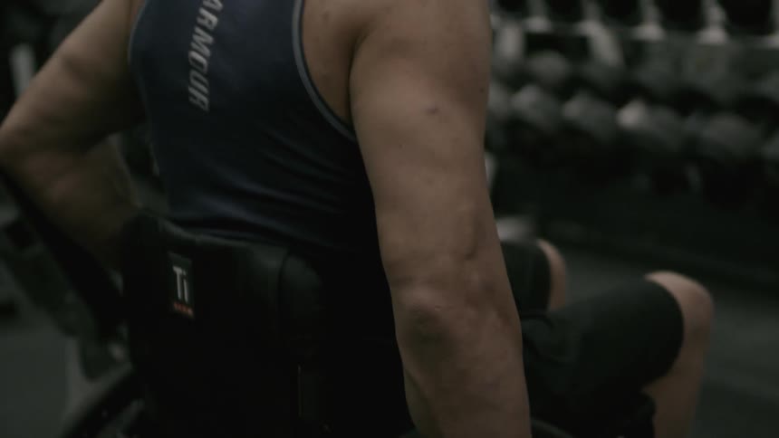 A man in a wheelchair is working out using weights