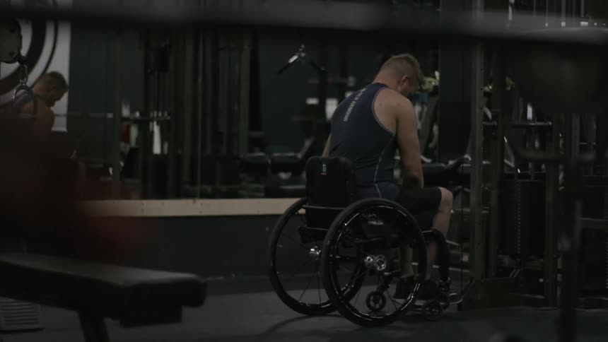 A man in a wheelchair goes to work out in a gym
