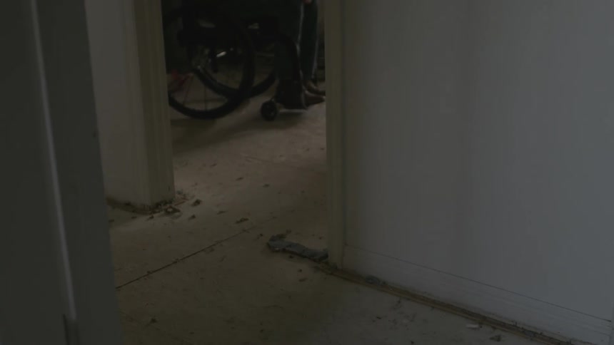 Person sitting in a wheelchair in a dim room