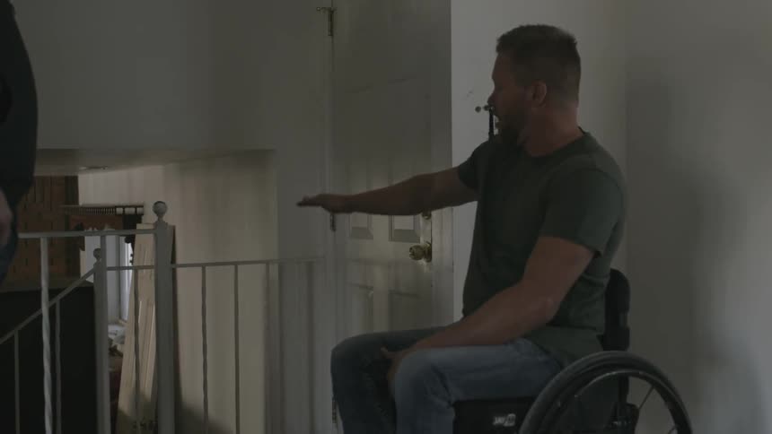 A man in a wheelchair talks with people in front of him
