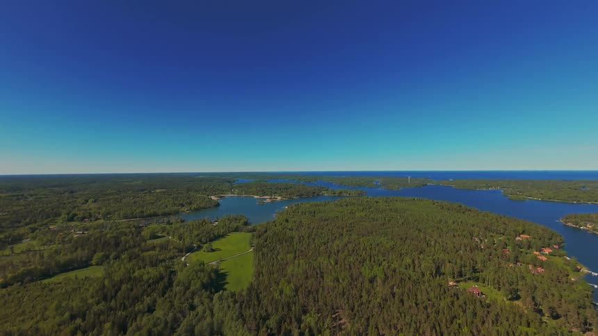 Stunning aerial wide shot of a lush green archipelago with calm blue water under a clear summer sky