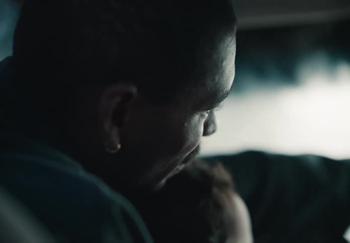 Intimate close-up of a father holding his baby on his lap as they drive through an automated car wash
