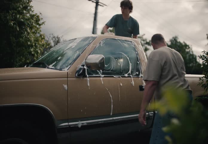A father and son team up to wash their soapy pickup truck together in slow motion