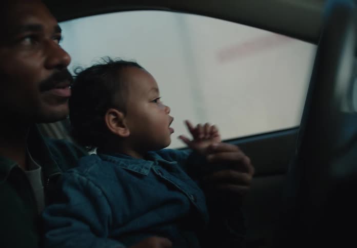 A loving father and his toddler share a sweet moment in the car, looking out the window together