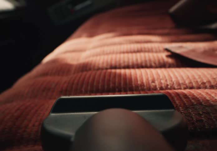 First-person perspective of a vacuum cleaner cleaning the red fabric upholstery of a car seat