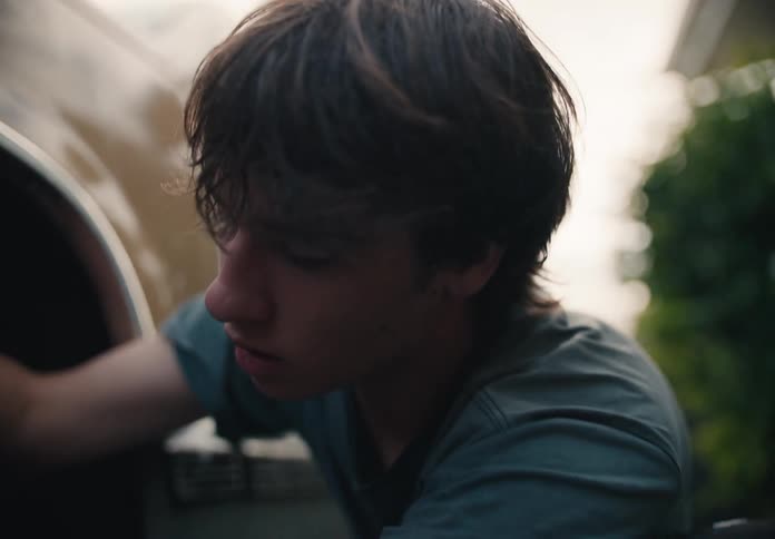 Close up of a concentrated young man washing the tire of a vintage car