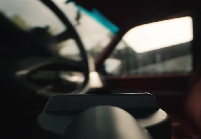 POV close up of a vacuum cleaner nozzle moving into a vintage pickup truck and cleaning the red corduroy seats