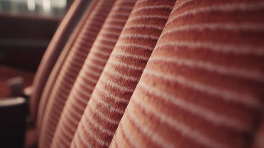 A macro close-up shot reveals the striped red velour fabric of a vintage car's interior seats