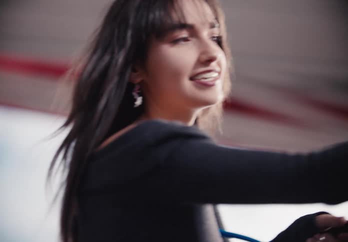A beautiful young woman with braces smiles joyfully in slow-motion as her hair flows in the wind
