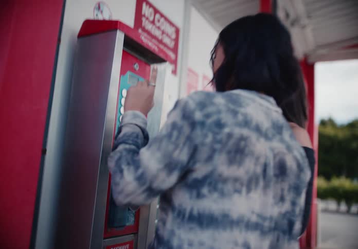 A group of young friends have fun washing their car at a self-service car wash on a sunny day