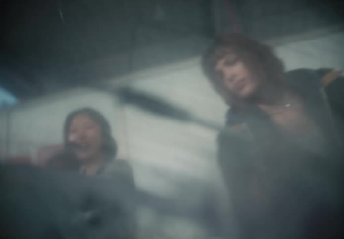 A group of friends have fun washing a car, filmed from inside the vehicle looking out the soapy window in slow motion