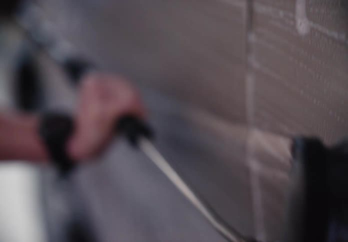 A dreamy slow-motion close-up of a person washing a car with a soapy brush