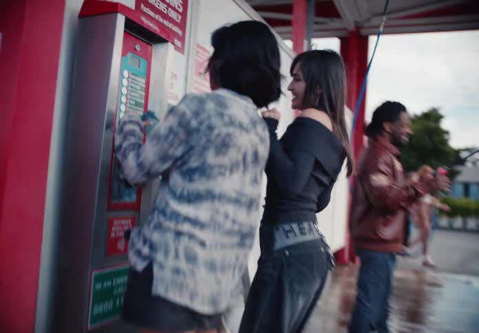 A group of energetic young friends dances and laughs while getting ready to wash their car at a self-service bay