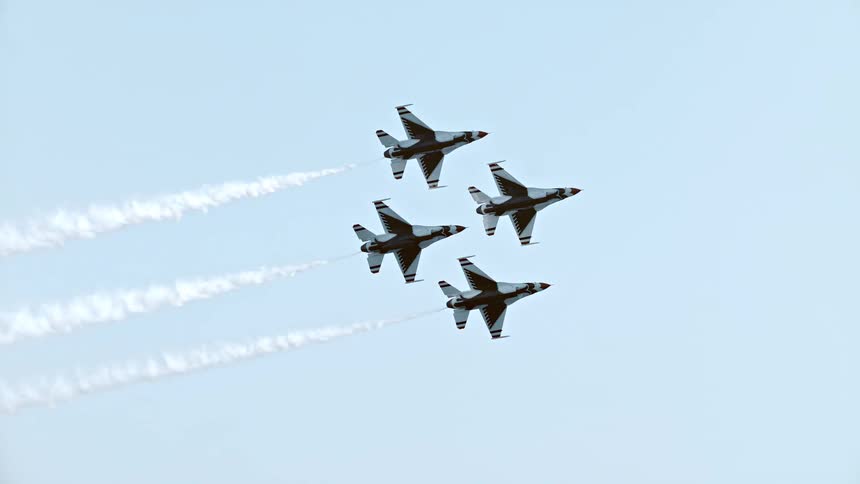 Four fighter jets fly in perfect diamond formation with smoke trails in a beautiful slow-motion airshow performance