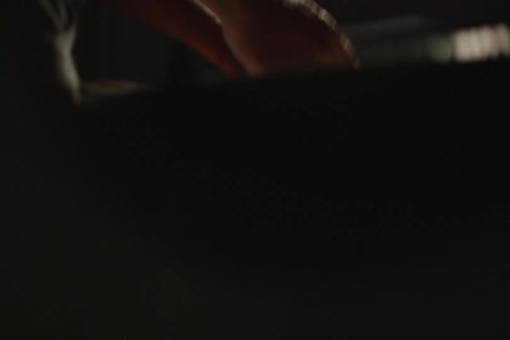 Close up of a baker's hands sprinkling flour over dough balls in a sunlit bakery, captured in slow motion