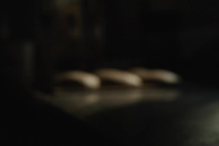 An artistic, abstract, shaky shot of bread dough buns on a baking tray