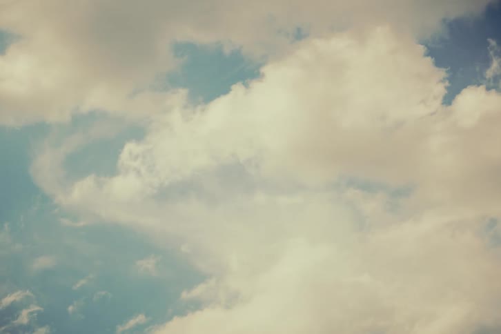 Peaceful vintage-toned footage of clouds gently floating across the sky