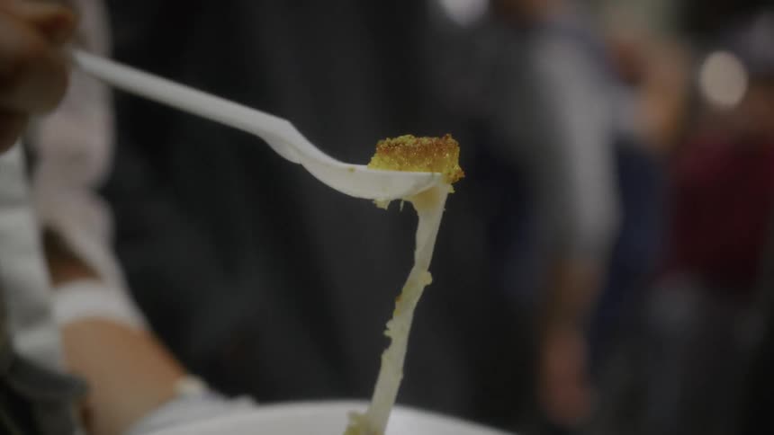 Savoring a slice of traditional Knafeh dessert as the melted cheese stretches in a satisfying slow-motion pull