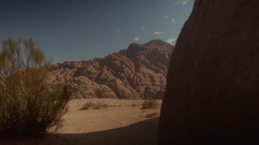 A slow dolly shot reveals the vast, rugged mountain landscape of the Sinai desert