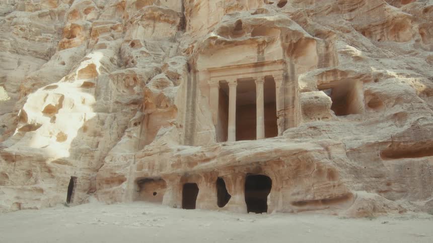 A historic Roman-style tomb is carved into the sandstone cliffs of Little Petra in Jordan